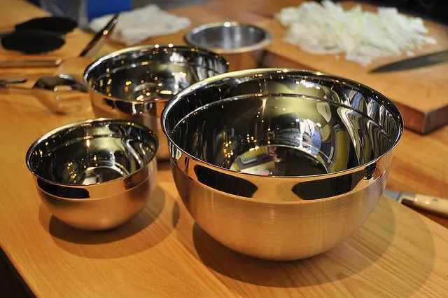 4 Stainless Steel Mixing bowls on a countertop, with chopped onions in background