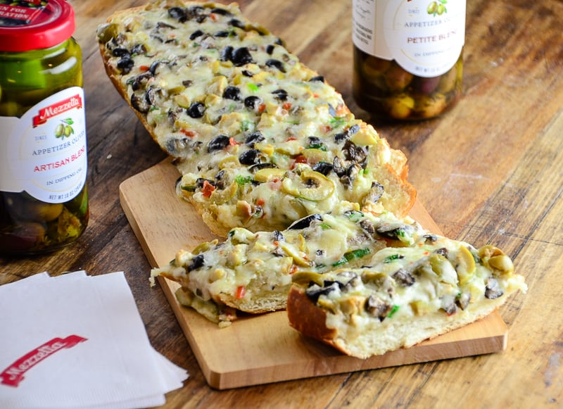 Sliced Olive Cheese Bread on a wooden werving board.