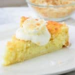 Impossible Pie on and white plate with a bowl of toasted coconut in the background