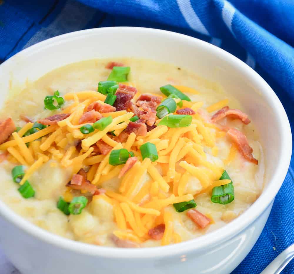 Loaded Baked Potato soup garnished with green onions, cheese, and crisy bacon pieces 