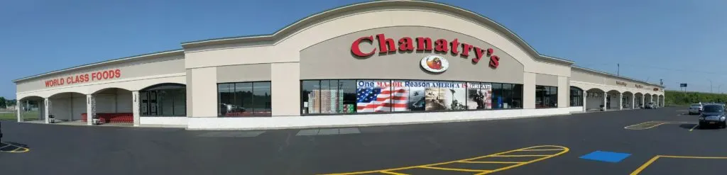 Panoramic view of the outside of Chanatry's Hometown Market in Utica New York. The beige store features a large red sign reading "Chanatry's"