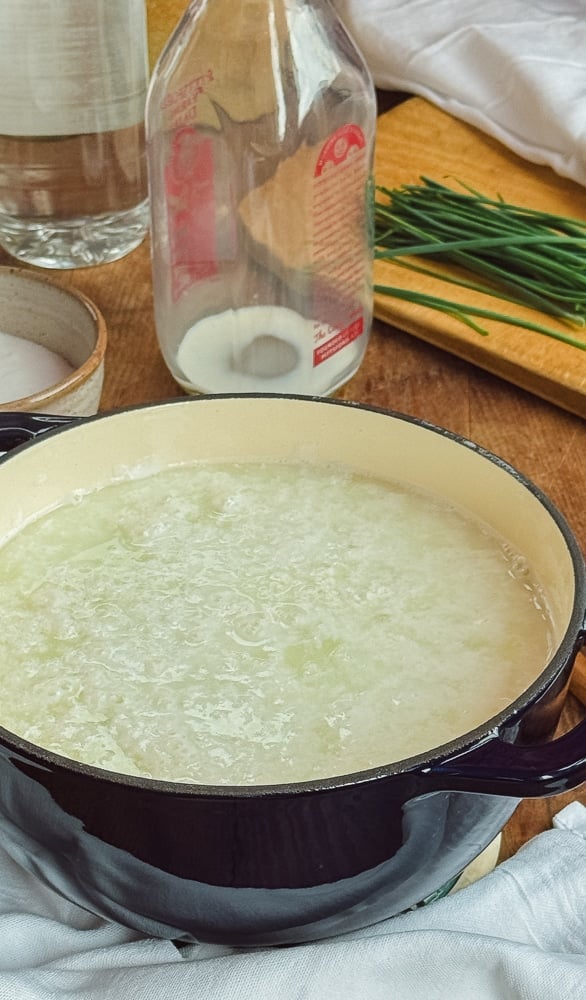 Milk curds separating from whey in a Dutch oven during the farmers cheese making process